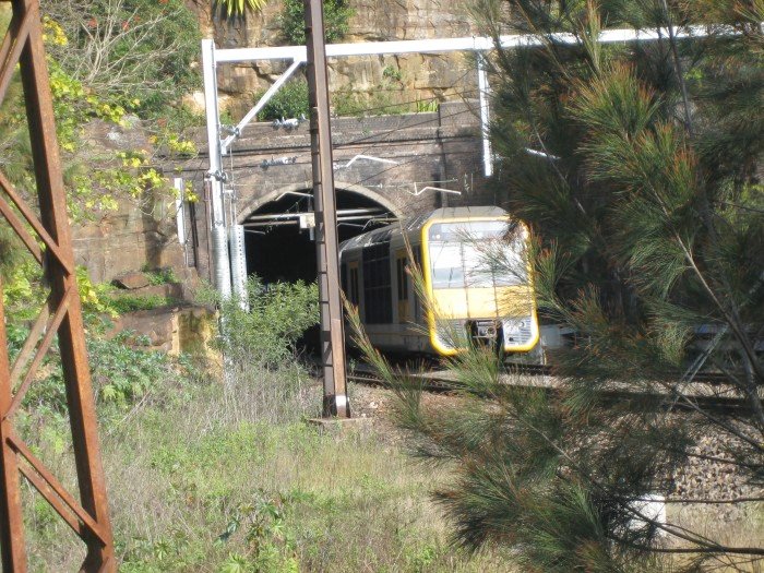 A Hornsby-bound Tangara set exits the northern portal of the Bay Road Tunnel.