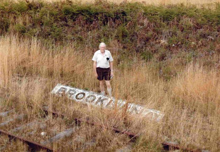 
The old station name-board, lying in the grass next to the track.
