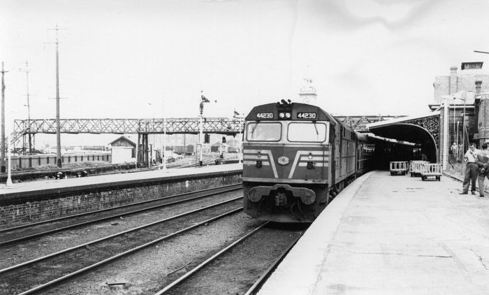 
44230 sits at the head of a passenger train bound for Sydney.  At the
left is the part of the extensive goods yard, now long gone.
