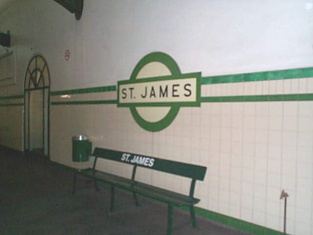 
The older-style bench seat and station sign board typical of the station.
