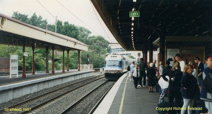 A down North Coast XPT approaches platform 3 as passengers wait to board.