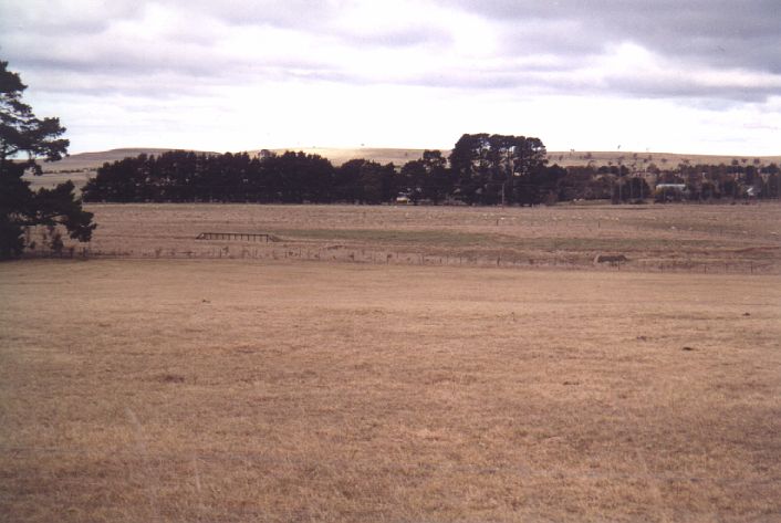 The view looking across towards Taralga.  The loading bank is visible on
the left and the remains of the turntable pit are on the right.  The
station was opposite the bank near the large tree.
