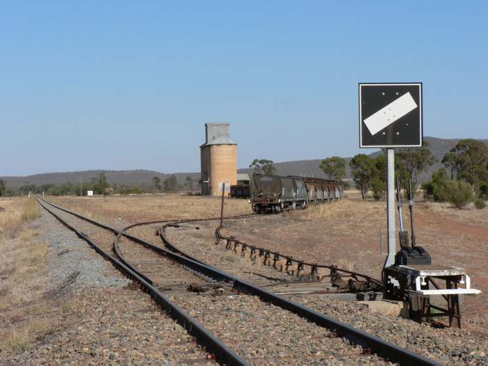 The view looking west. The one-time station was on the left of the main line opposite the silos.