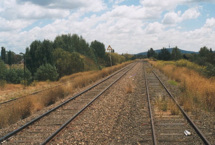 The view of the Canberra branch line at Fyshwick looking towards Canberra station.  The line on the far left is the original line into Canberra which was subject to occasional flooding and was replaced in the 1970s by the two higher-level tracks of the current line.
