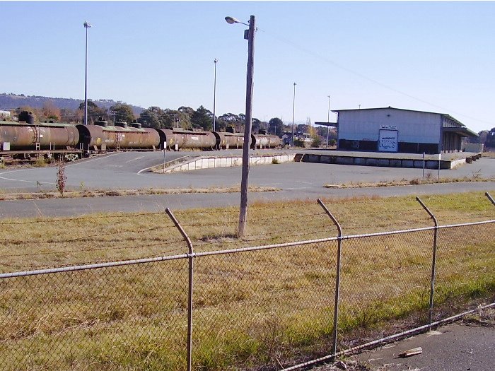 A view from the Canberra railway museum across the yards showing the good shed and the sidings used to store tankers from the oil terminal.  The Canberra station can be seen in the distance between the last tanker and the goods shed.  (22-May-2005).