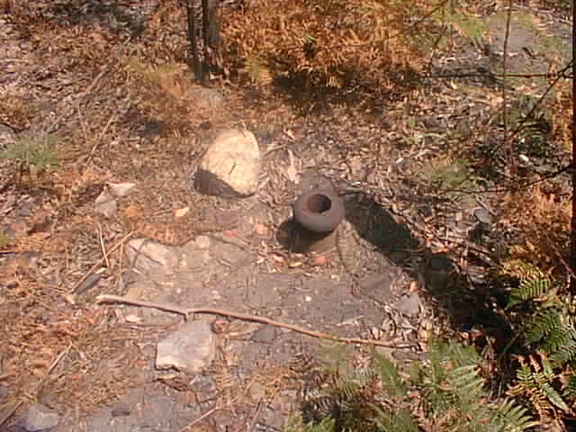 The base of a former telegraph pole near the old alignment.