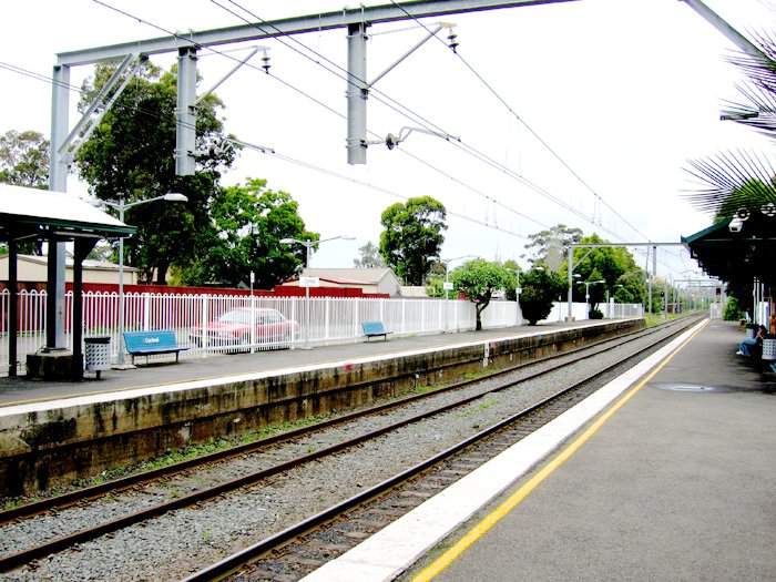 Looking towards Wollongong from up platform. Notice the older style white station signs with more recent blue seats.