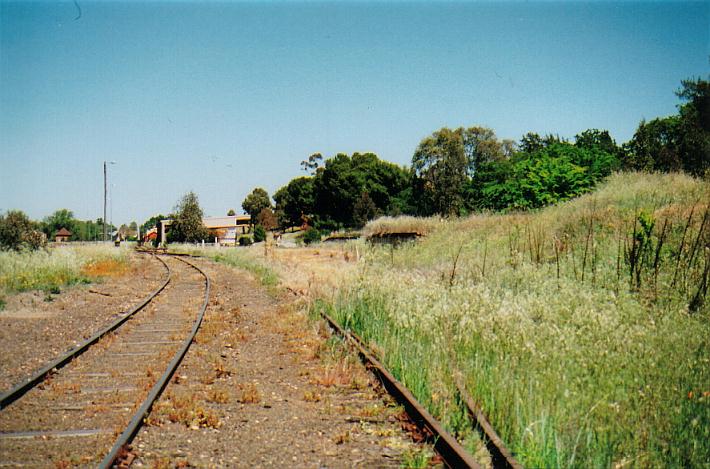 
An overview from the northern end of the yard, with a goods bank to the right
and what's left of the over grown yard, the goods shed in front, and in the
far distance the station and signal box.
