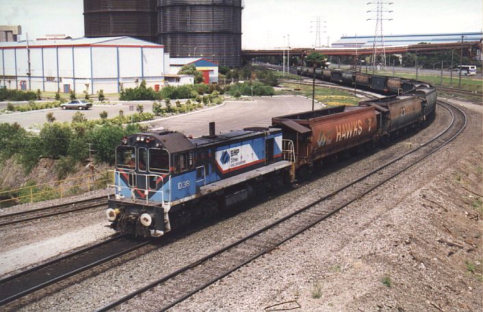 
BHP locomotive D38 hauls a short coal train past the station at Cringila.
