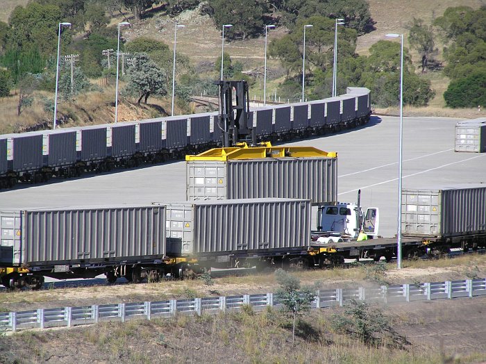 A close up view of the transfer of the container from carriage to truck, looking south. 