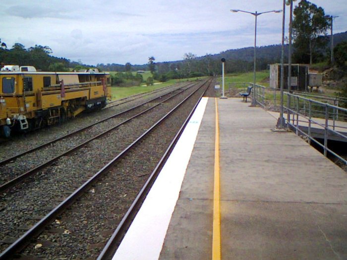 Track machines are stabled in the siding to be used for nearby re-sleepering works.
