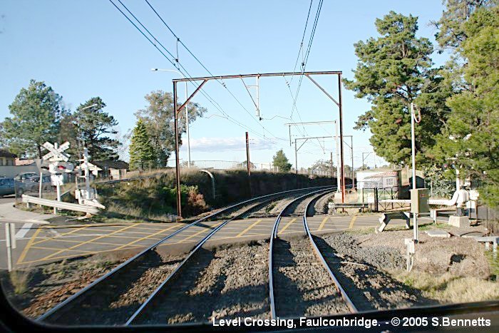 A view of the  level crossing at Faulconbridge taken from the rear of a Katoomba-bound train.