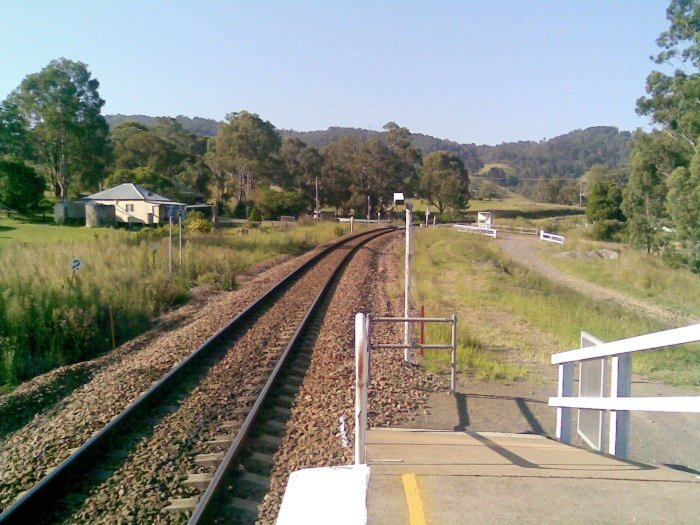 The view looking towards Dungog, with CCTV camera, level crossing and level crossing control hut in the background.