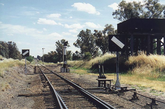 
Looking south from Koorawatha at the junction of the line to Grenfell.
A mixture of technologies, with the steam era water tank, semaphore
and train order signals.  By this time, the station has been removed.
