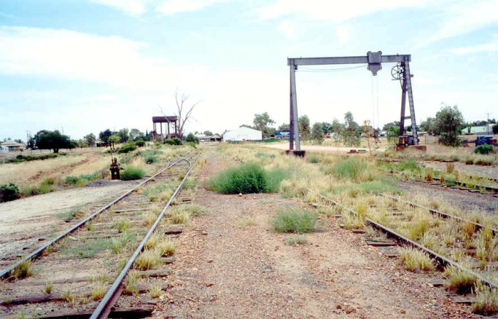 The view looking towards the terminus, showing the water tank, gantry crane and overgrown yard. The station was located directly on the left. The siding next to the crane leads to the turntable and former loco servicing facilities.
