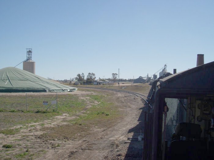 The view of the silo siding to load grain trains. The green tarp on the left is covering a 'strip' of grain waiting to be moved by rail. Looking towards Pokataroo.