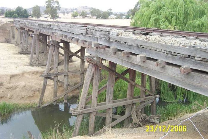 The ballasted trestle bridge over a small creek is in excellent condition, holes between the sleepers where they have rotted have been covered with boards. It appears that the farmers use the bridge to move the sheep from paddock to paddock.