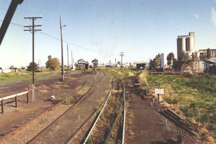 The view looking south from an engine leaving Moree. On the left can be seen Moree Loco. Behind the white fence at the far left is the siding leading to the turntable. In the distance, the main line in on the right, with the Inverell branch on the left.