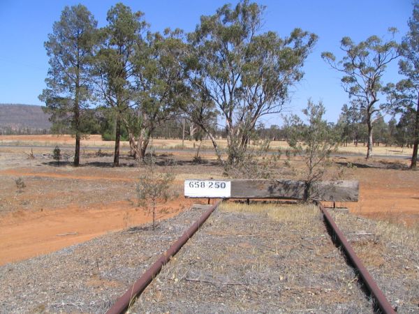 A stop block at the end of the line.  The Rankins Springs to Lake Cargelligo road runs in the background.