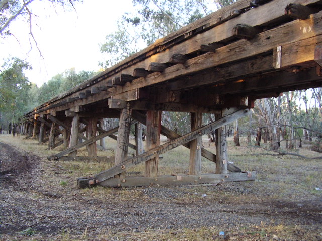 The Tocumwal line approaches the Murrumbidgee River from Narrandera over a ballasted timber trestle.  A view of the western side of the trestle on the northern bank of the river.