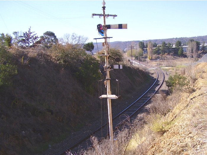 After leaving Queanbeyan station heading to Goulburn, the line passes through a small cutting and then onto the bridge over the Queanbeyan River.  A view from the cutting showing the home signal just before the Queanbeyan station with the bridge in the distance.