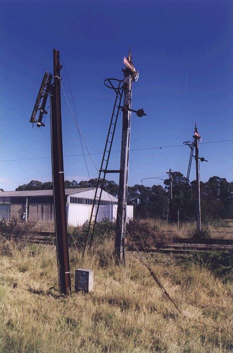 
A couple of semaphores signals controlling the approach to Ropes Creek
station from the north.  Note the remnants of catenary hanging in the
background.
