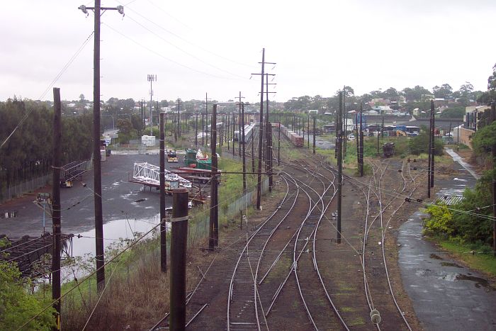 
The view looking west over the Goods Yard.  The former Gordon Street sidings
are on the right, with the main yard in the distance.  In the yard are some
Tulloch passenger cars awaiting demolition and a freight train on the arrival
road.  Note the tracks cut in the foreground, which led to the grain and
freight loading facilities at White Bay.
