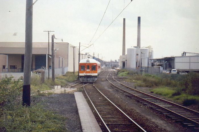A diesel railmotor set approaches Sandown platform in 1986, looking straight down the line to Camellia. 
