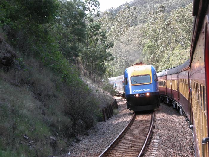 A north bound tour train crosses a south bound XPT at the northern end of the Stroud Road Loop. 