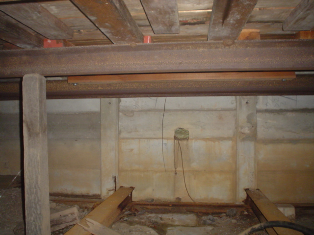 A view under the signal box showing its construction from concrete slabs and pieces of rail.