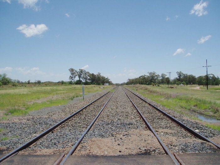 Turrawan Automatic Crossing Loop looking towards Narrabri. The staff hut is the white building on the left. There used to be an island platform where the left track (main line) is, with the down track curving around to where the staff hut is.