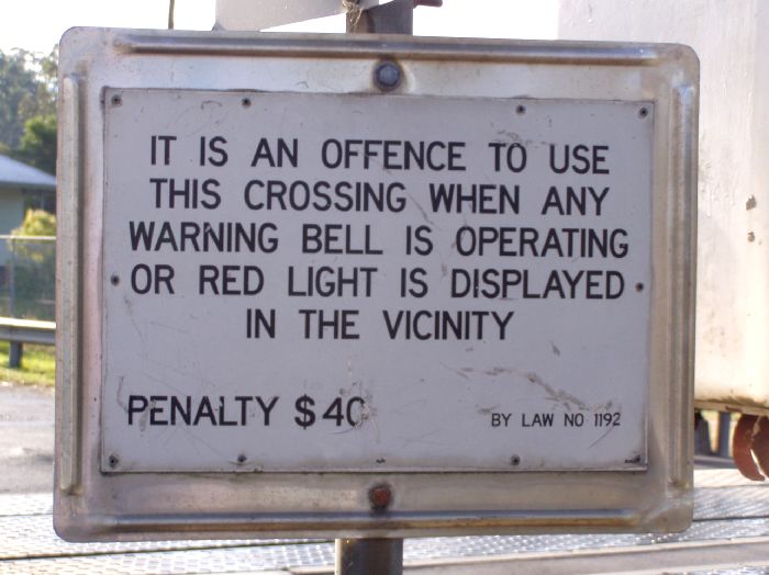 A standard warning sign for pedestrians crossing at the level crossing.